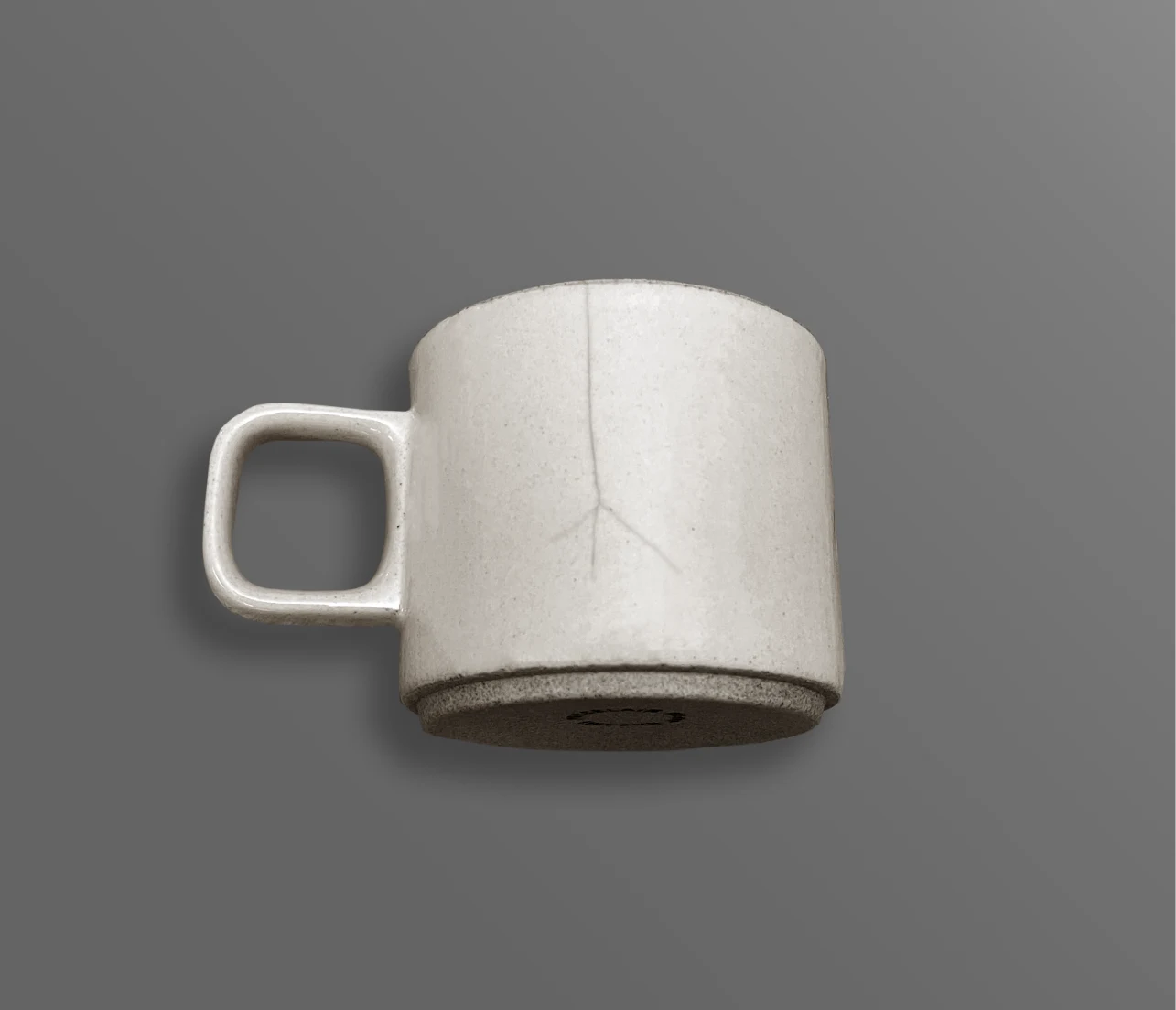 A pale ceramic mug with a hairline crack running down one side.